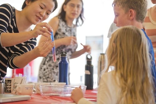 Student explains an experiment to children at the U chemistry festival