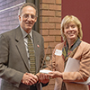 Milton Lee receives his Distinguished Alumnus Award from Cindy Burrows