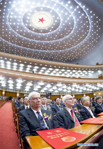 In a large formal room with an intricate ceiling, in Beijing, China, Prof. Peter Stang sits with the other awards recipients at the ceremony. 